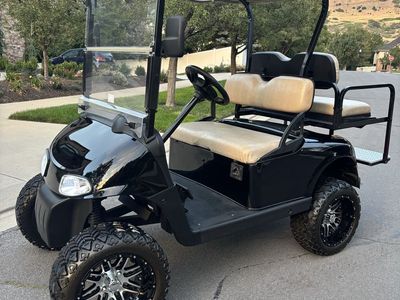 Custom Black Golf Cart with Lifted Wheels and Rear Seat