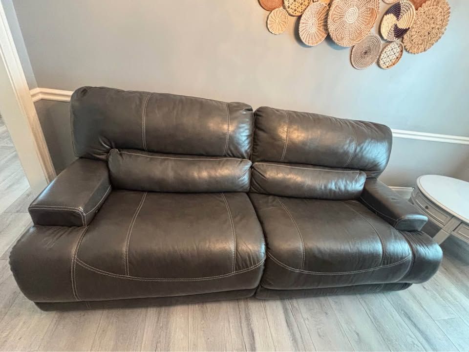 Ashley Furniture Reclining Leather Sofas - 1 Power, 1 Manual - Dark Gray with White Stitching
