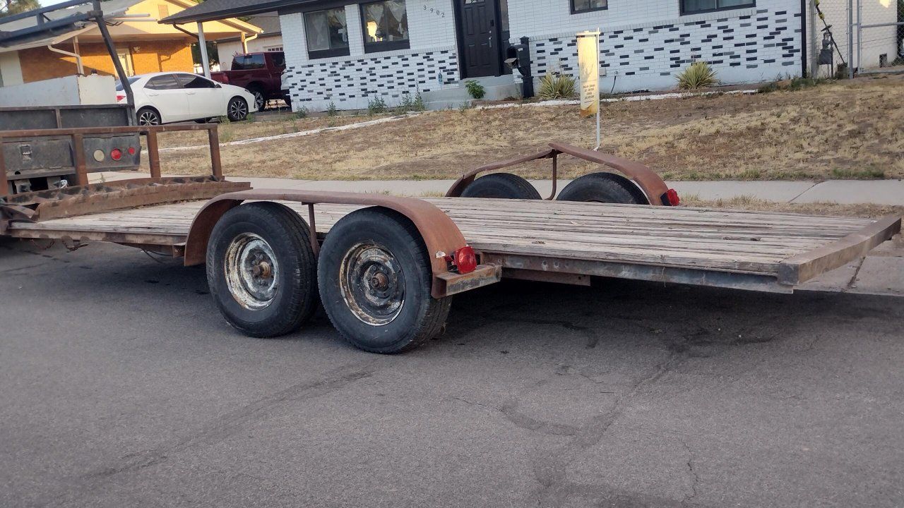 Heavy-duty dual axle trailer with brakes. This 18' foot flatbed trailer has a 10,000 lbs capacity with a weathered wooden deck a