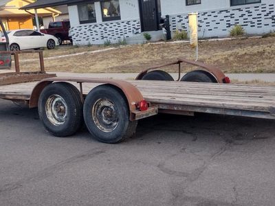Heavy-duty dual axle trailer with brakes. This 18' foot flatbed trailer has a 10,000 lbs capacity with a weathered wooden deck a