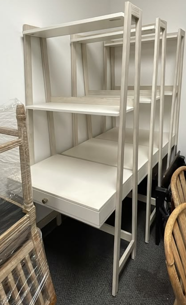 White ladder-style desk with integrated shelving and drawer.