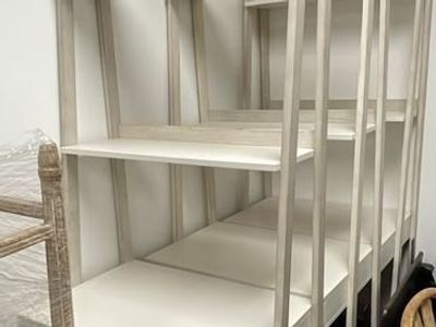 White ladder-style desk with integrated shelving and drawer.