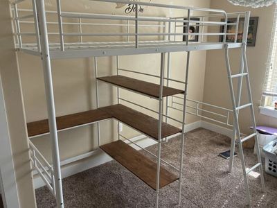 White loft bed with shelving, desk, and ladder