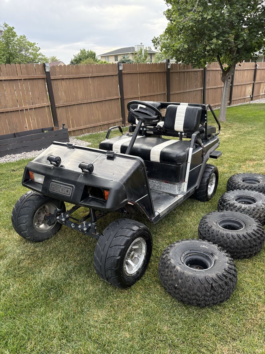 EZ Go Golf Cart - Black with White Stripes, Lifted with All-Terrain Tires, Includes Extra Set of atv Tires