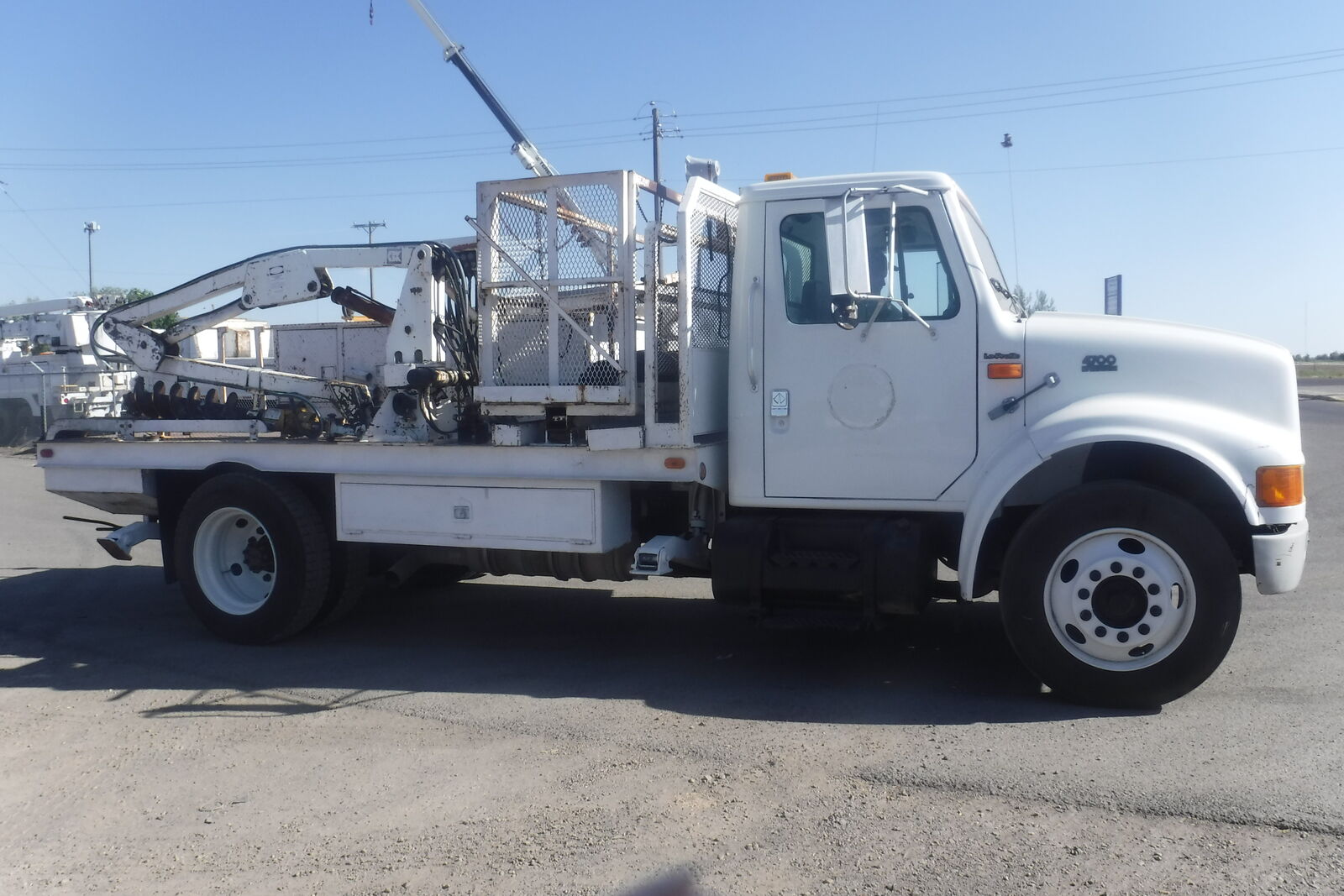 1997 IHC 4700 LoPro with hydraulic articulated post hole digger.