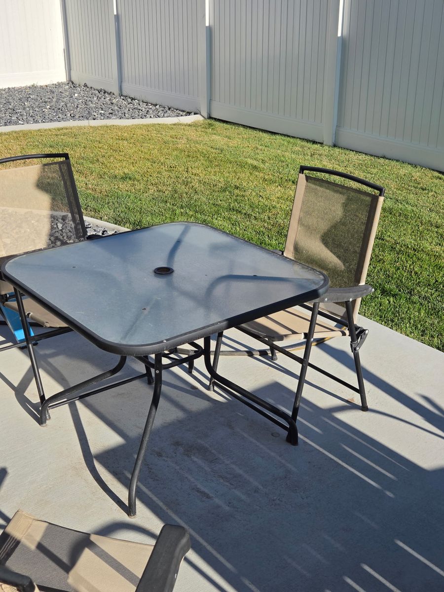 Glass outdoor table and folding chairs