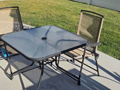Glass outdoor table and folding chairs