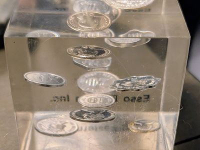 This vintage 1960s or 1970s Lucite paperweight features encased Canadian coins