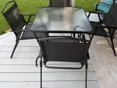 Black Metal Patio Set with Square Glass Table and Four Folding Chairs
