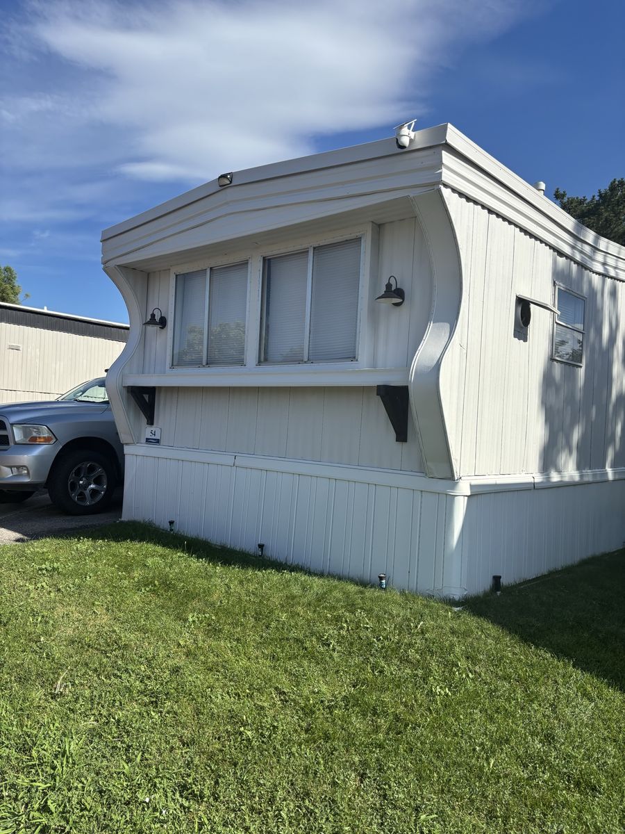 Manufactured Mobile Home with White Siding and Fenced Yard