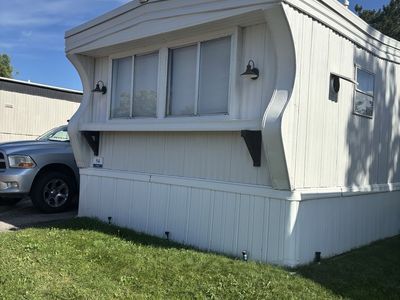 Manufactured Mobile Home with White Siding and Fenced Yard