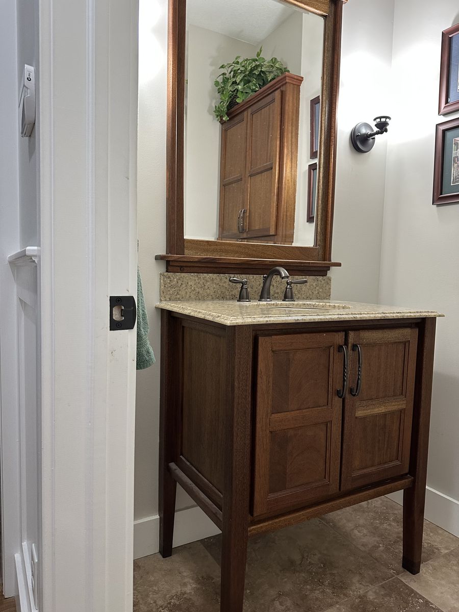 Wooden Bathroom Vanity with Marble Top, Undermount Sink, including Faucet, and matching Mirror Frame.