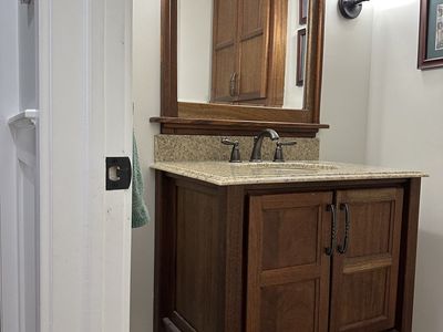 Wooden Bathroom Vanity with Marble Top, Undermount Sink, including Faucet, and matching Mirror Frame.