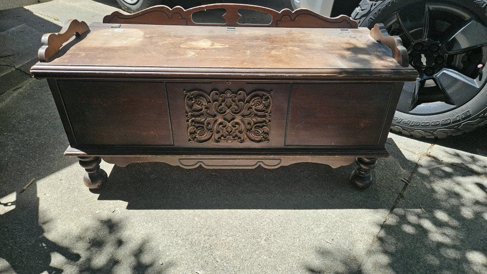Vintage Wooden Storage Chest with Ornate Carved Front and Bun Feet