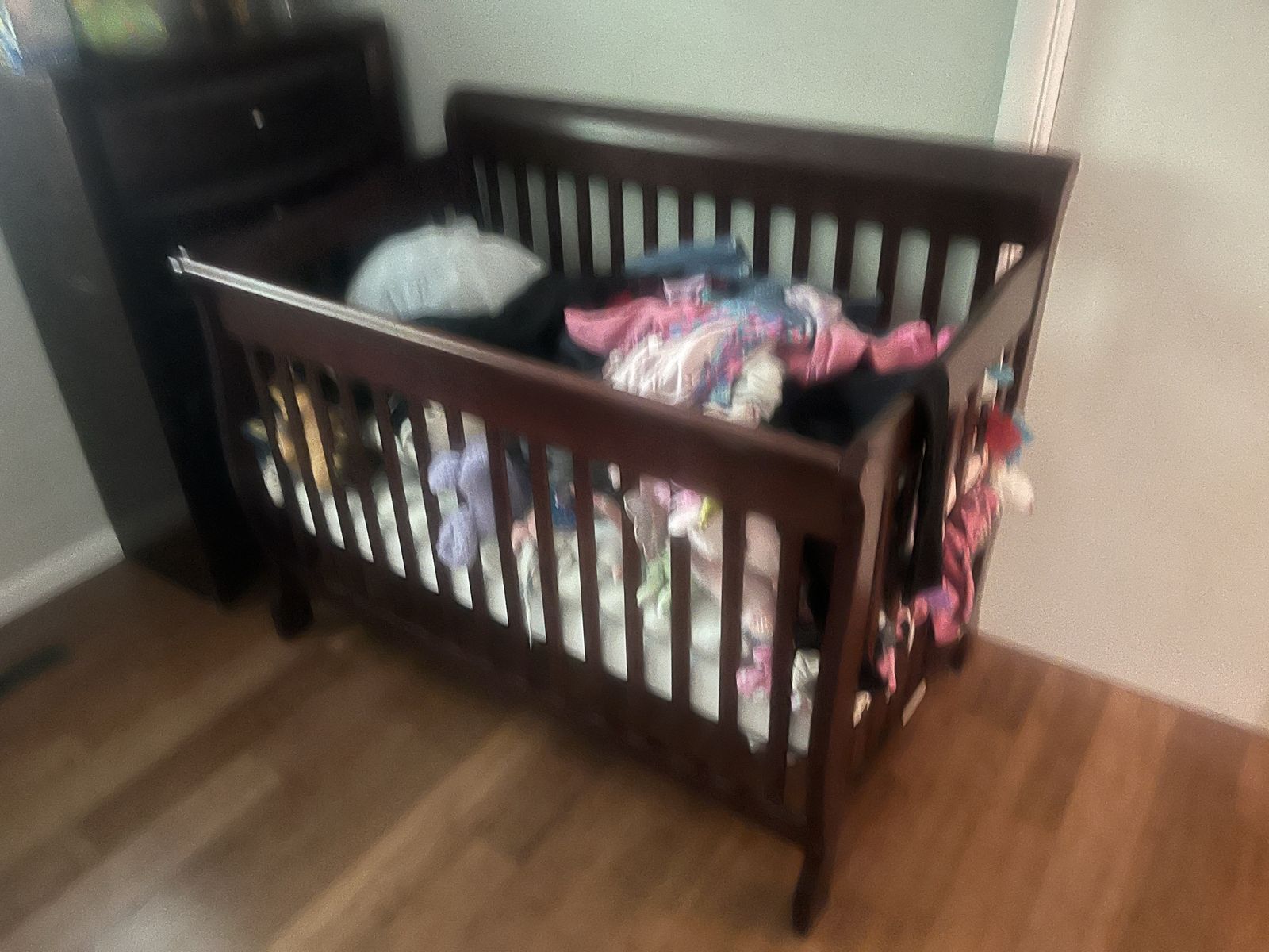 Dark brown baby crib with mattress and cover