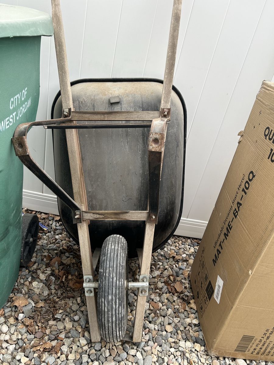 Garden wheelbarrow with a dark-colored bin, wooden handles