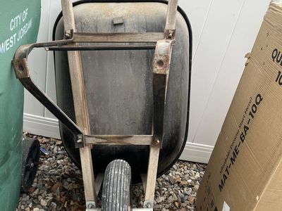 Garden wheelbarrow with a dark-colored bin, wooden handles