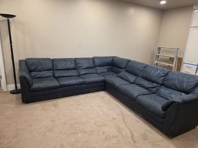 Large Dark Blue Leather Sectional Sofa with Visible Wear and Scratches