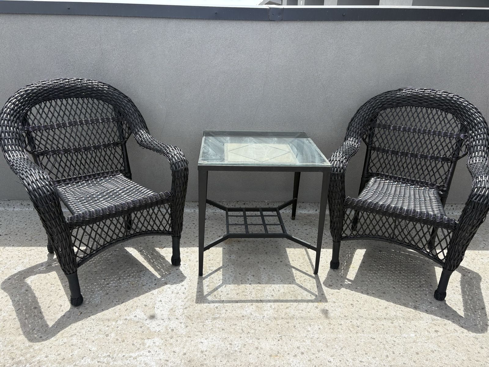 Two wicker chairs and glass table