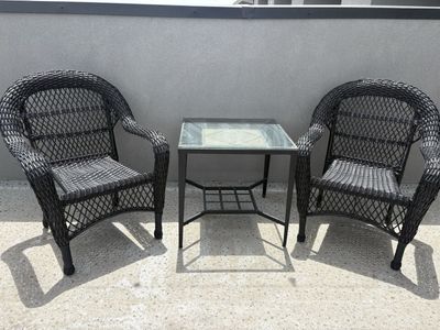Two wicker chairs and glass table