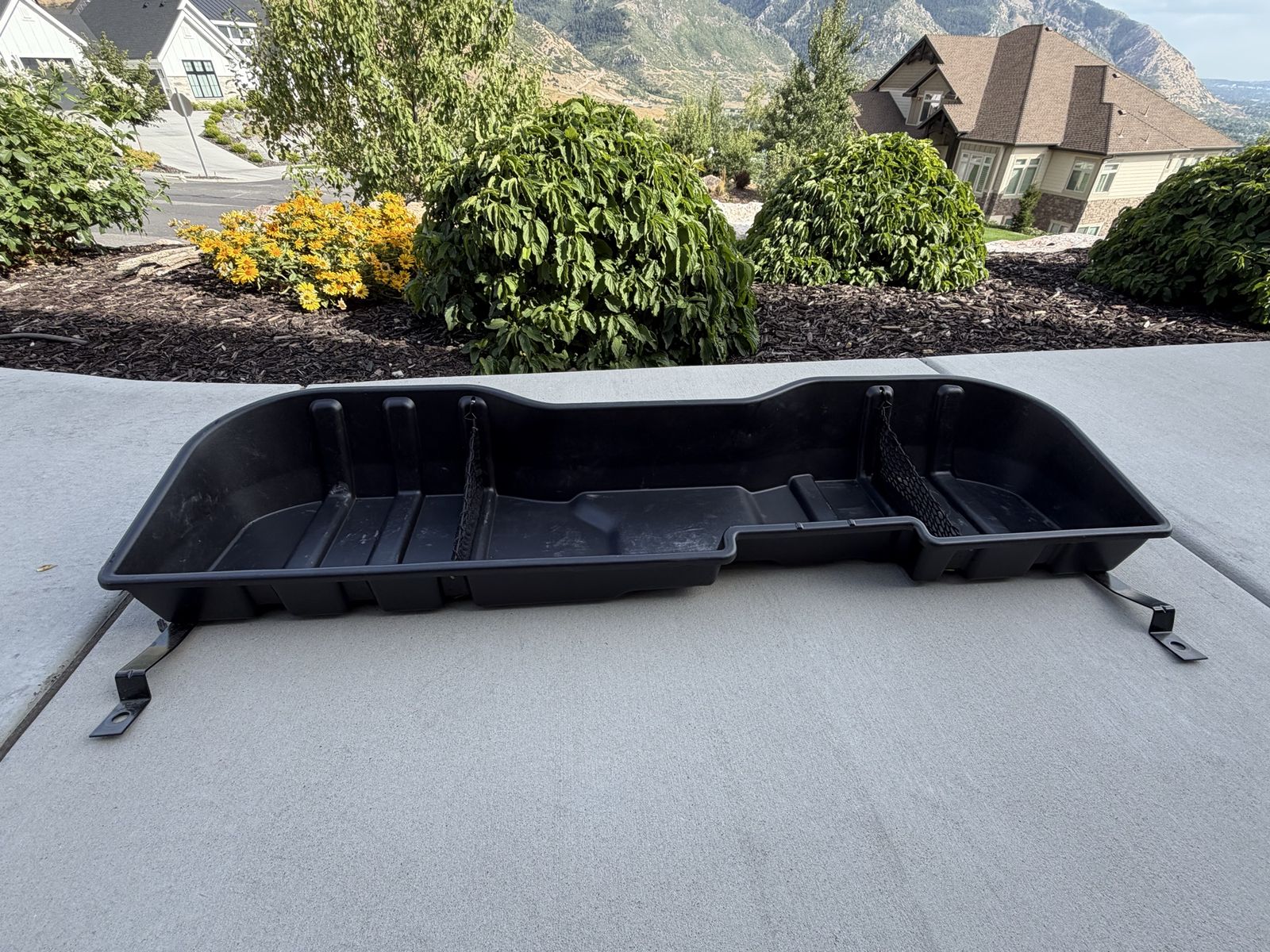 Black Plastic Under-Seat Storage Bin Organizer for a GMC Sierra 3500. 