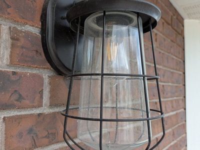 Black Outdoor Wall Sconce Light Fixture with Metal Cage and Clear Glass Shade