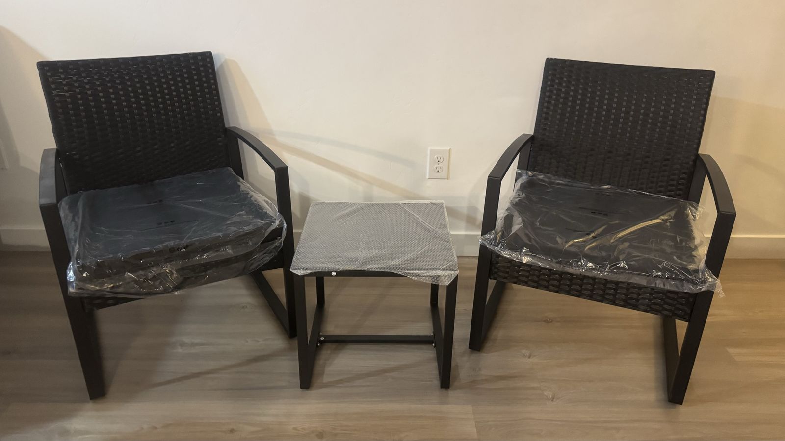 Outdoor furniture: two chairs and a small table with a glass top.