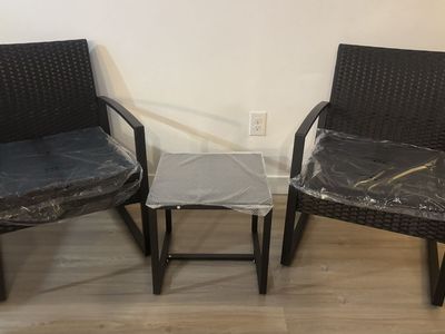 Outdoor furniture: two chairs and a small table with a glass top.