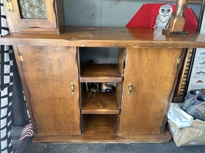 Vintage maple wood hutch features a top cabinet with glass paneling and lower storage cabinets.