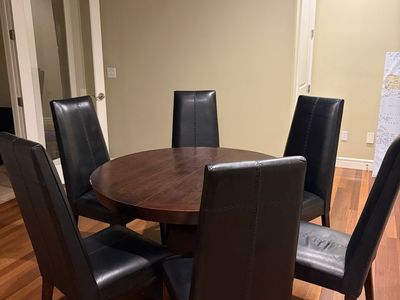 Dark Wood Round Dining Table with 6 Black Leather Chairs