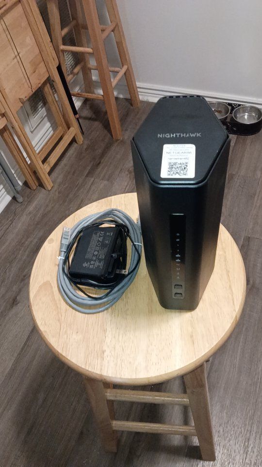Netgear Nighthawk BE9300 Wi-Fi 7 Cable Modem Wi-Fi Router Combo with Power Supply and Ethernet Cable.