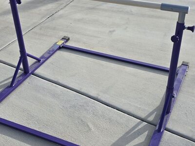 Adjustable gymnastics bar with pad
