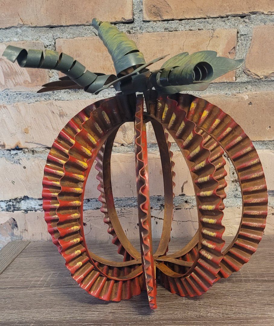 Metal pumpkin with a wavy banded design and curly