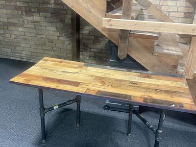 Table with wood finished top and pipe legs