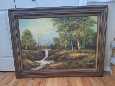 Vintage framed oil landscape painting featuring a forest waterfall scene. 44" wide x 32.5" tall.