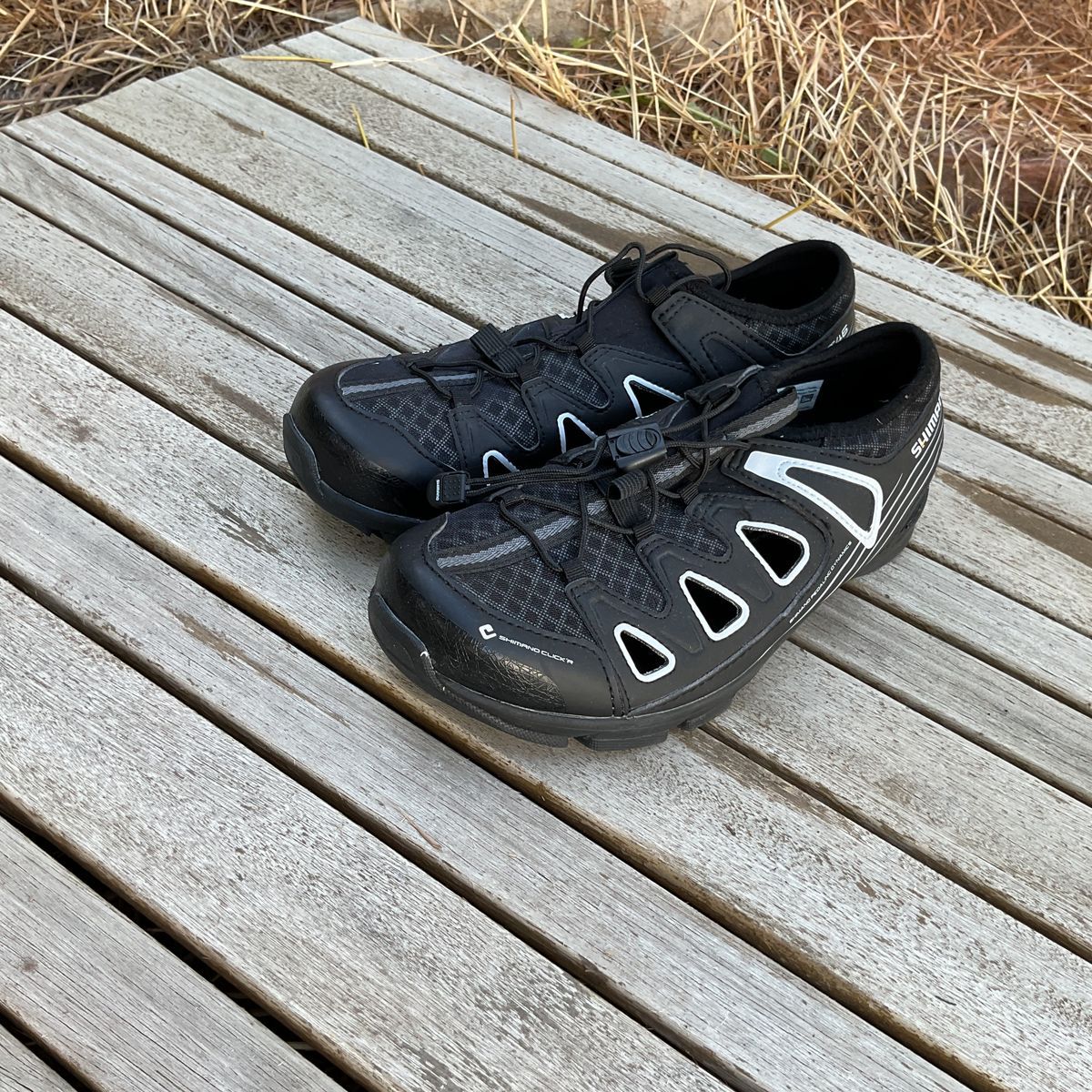 black and white spin shoes with mesh holes in the sides
