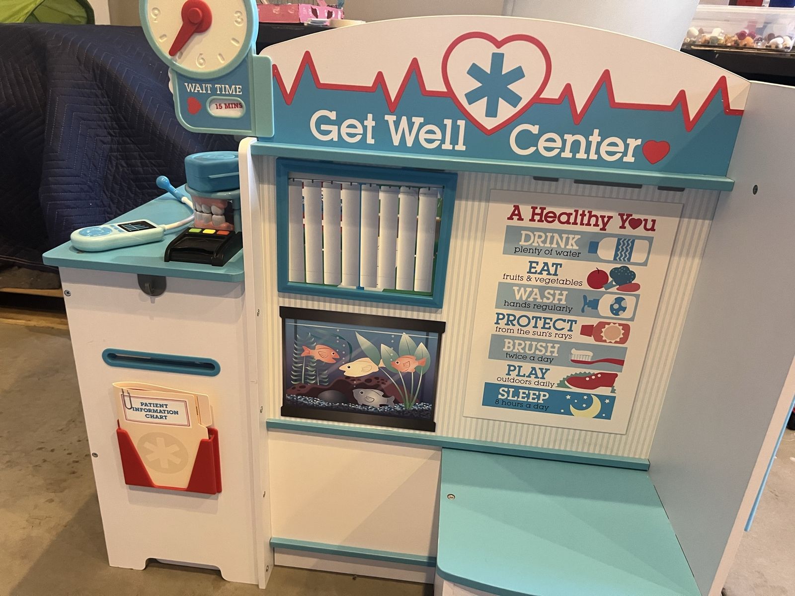 Melissa & Doug Get Well Doctor Activity Center, featuring a multi-sided wooden design with a built-in clock