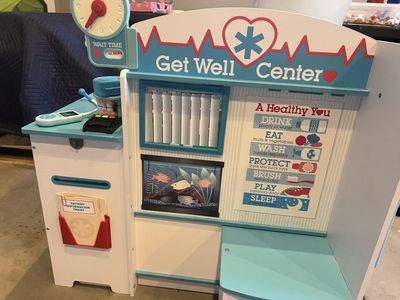 Melissa & Doug Get Well Doctor Activity Center, featuring a multi-sided wooden design with a built-in clock
