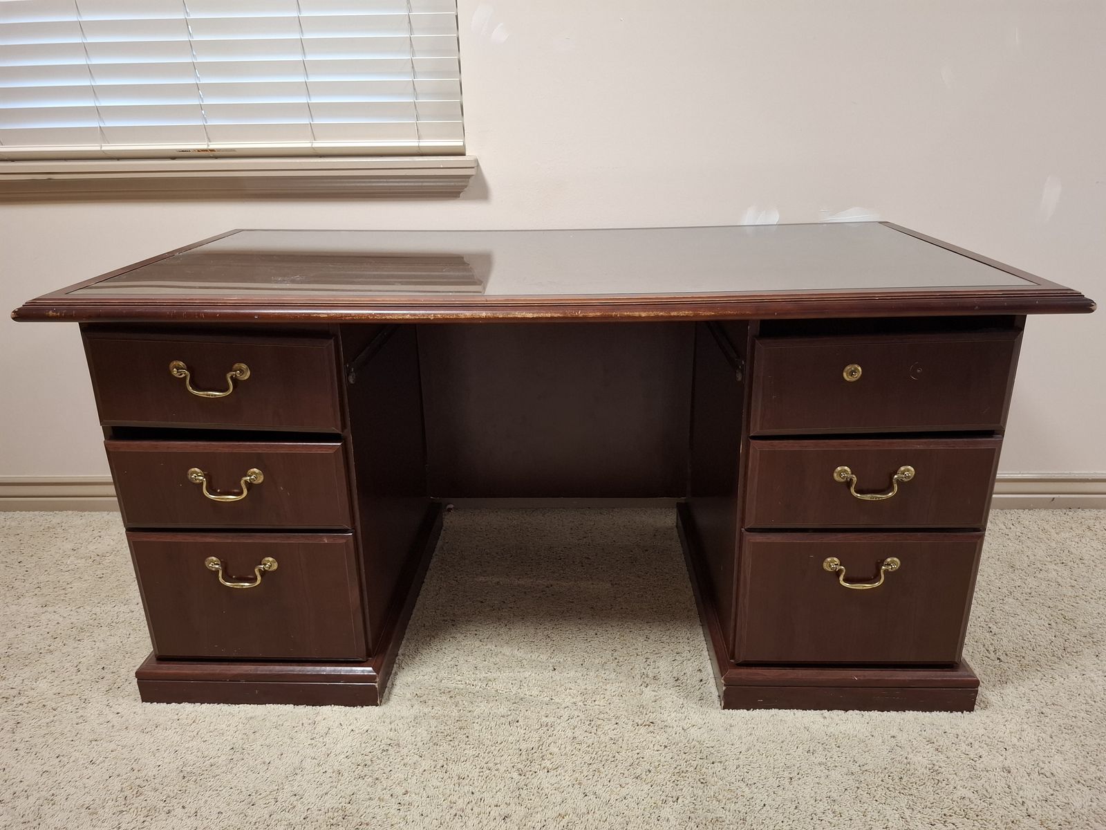 Wooden office desk with glass top and drawers