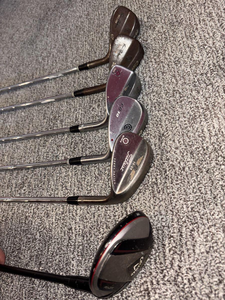 Various golf wedges and 3 wood.