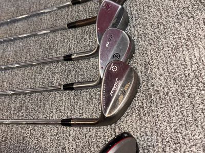 Various golf wedges and 3 wood.