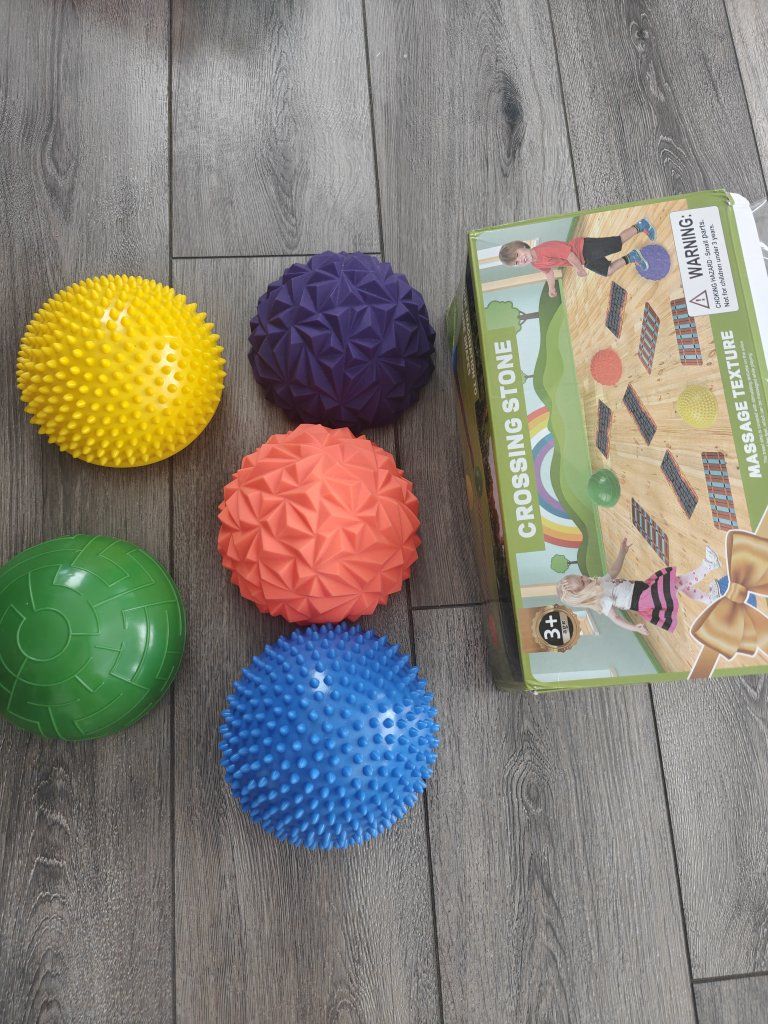 The toy is a YEIBOBO Crossing Stone, a set of massage balancing hemispheres and tracks for developing coordination.