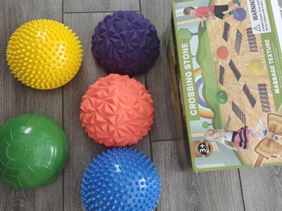 The toy is a YEIBOBO Crossing Stone, a set of massage balancing hemispheres and tracks for developing coordination.