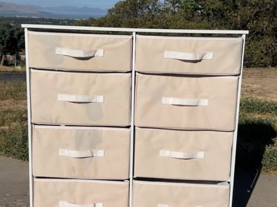 Versatile storage dresser has a white steel frame with a hard wood top and eight removable pink fabric drawers.