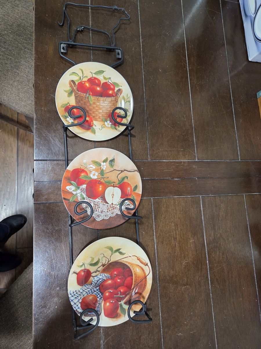 3 decorative plates in metal holder with a cow on top