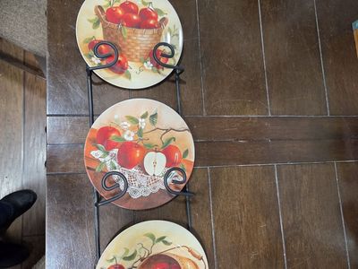 3 decorative plates in metal holder with a cow on top