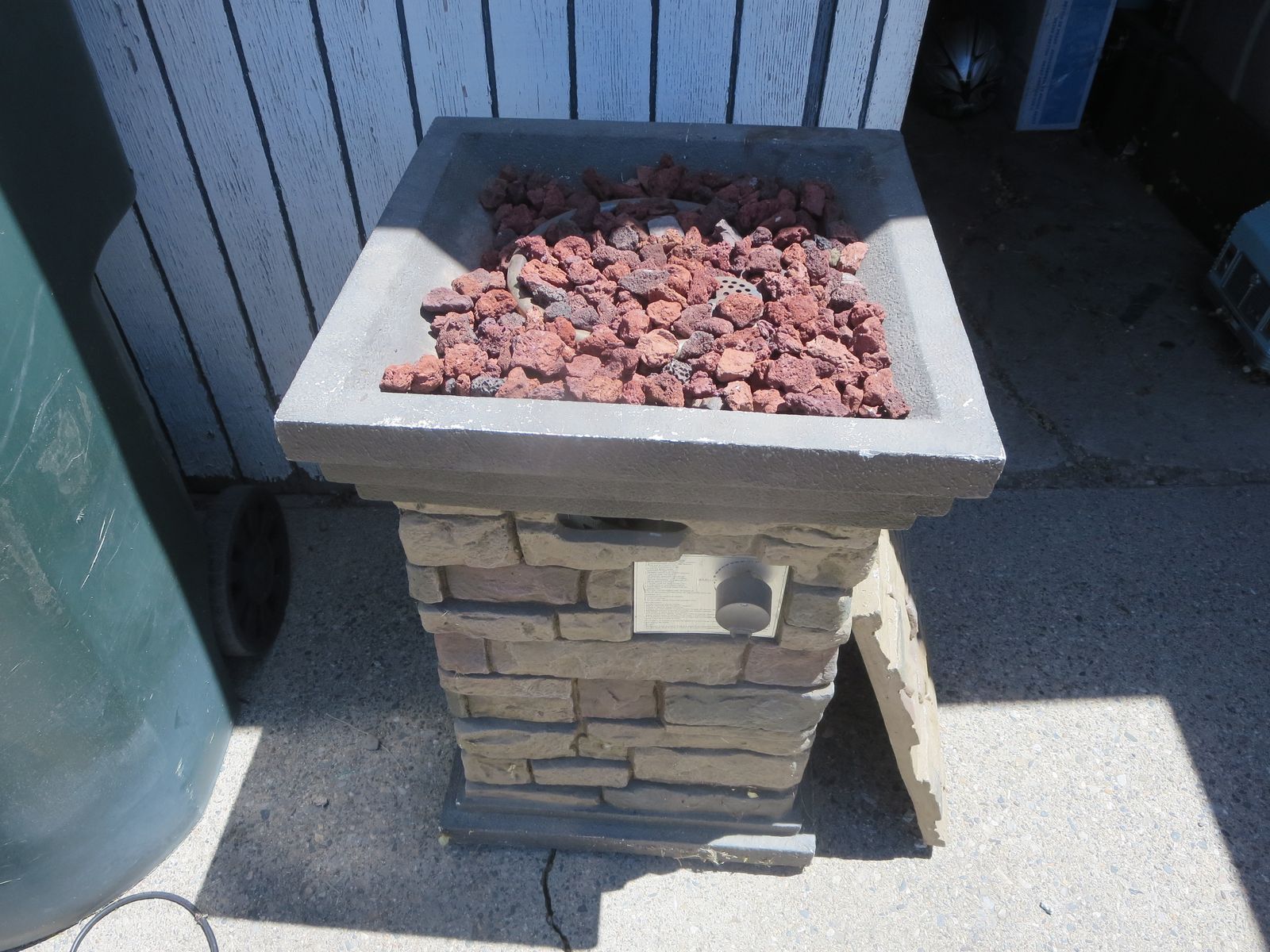 Propane square fire pit with lava rocks and propane tank