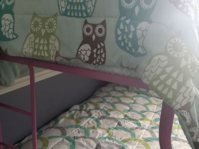 Pink twin over double Bunk Bed with Mattresses and Bedding.