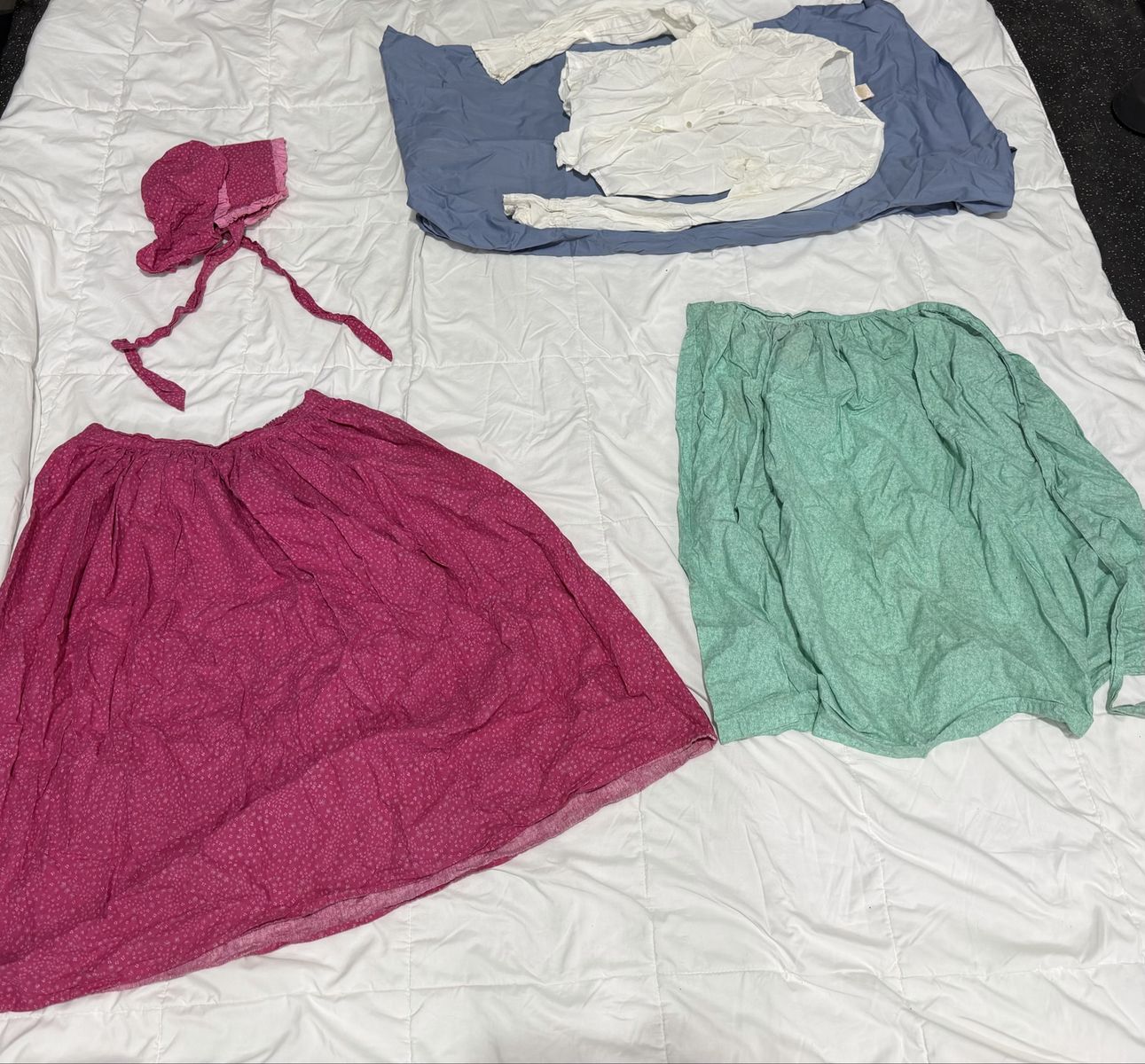 Dark pink pioneer skirt with matching bonnet, white blouse, and cute mint green apron.