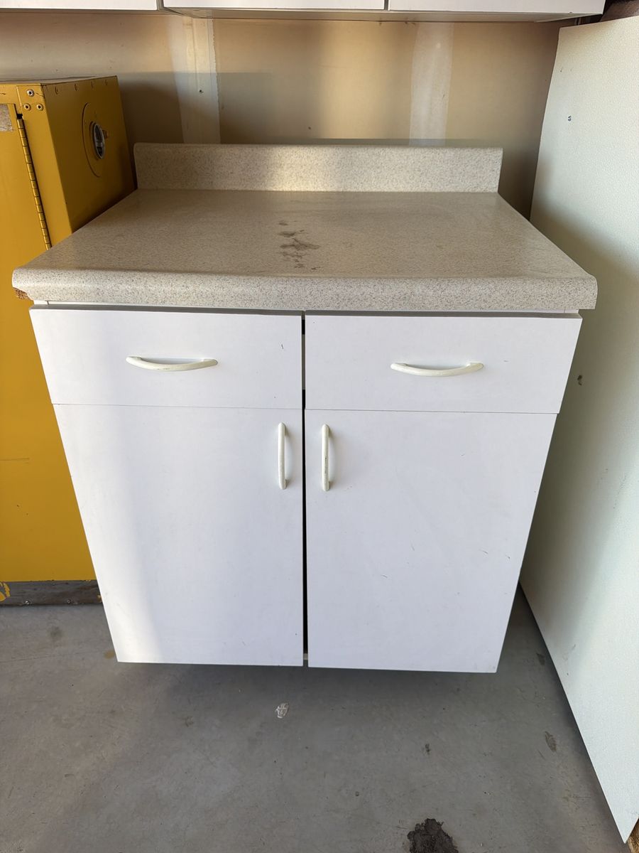 White Kitchen Cabinet with Countertop and Drawers used in garage as shelving